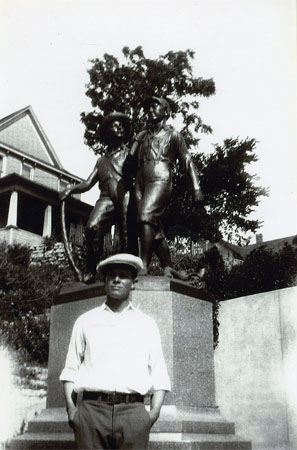 <Burt in Hannibal MO abt 1928 or 1929 posed before the statue of 
Tom Sawyer and Huckleberry Finn. A man from Erick OK was moving to Hannibal 
and paid Daddy to ride in the railroad car that he was shipping his furniture in.>
