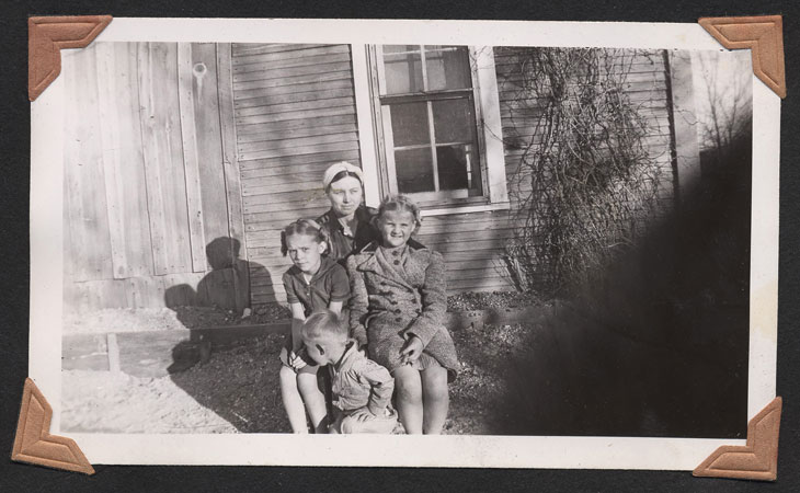 <johnie adrienne terry jean posed on south side of ranch house on a cold day. adrienne and terry no coat.>