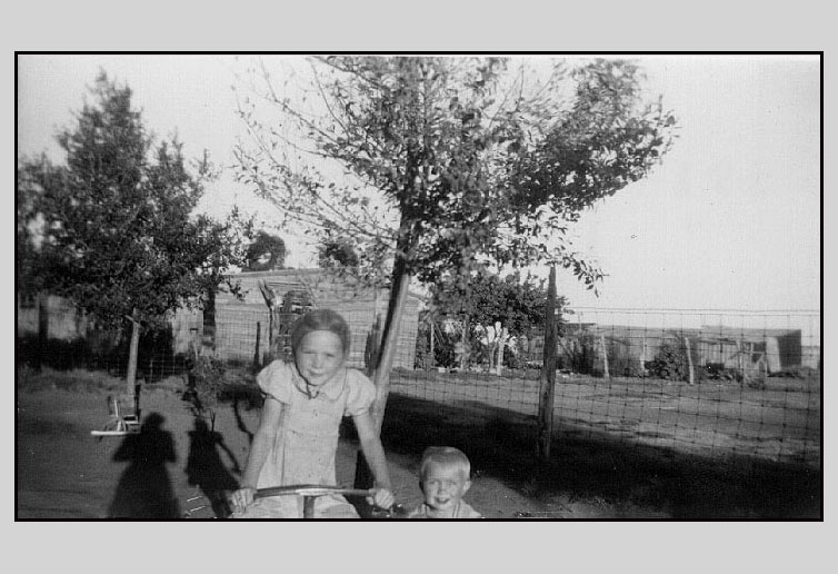 <adrinene on tricycle and terry grandma turner's house and the barn shown in the background>